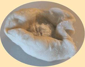 A small amount of flour is encased in a hollow of a piece of dough